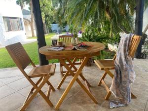 una mesa de madera y 2 sillas en el patio en Casa Iola, en Cancún