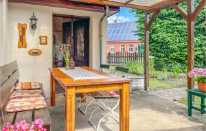 Awesome Home In Dabel With Wifi في Dabel: طاولة وكراسي خشبية على الفناء