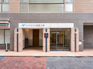 une entrée à un bâtiment avec un panneau sur celui-ci dans l'établissement Court Hotel Fukuoka Tenjin, à Fukuoka