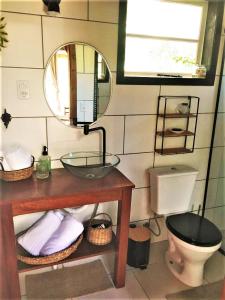 a bathroom with a sink and a toilet and a mirror at Cabana dos Sonhos na Serra SC in Rancho Queimado