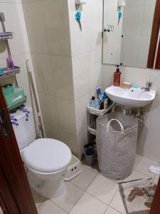 a bathroom with a toilet and a sink at busy city street in Cihuni