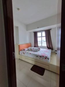 a small bedroom with a bed and a window at busy city street in Cihuni