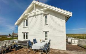 een wit huis met een tafel en stoelen op een terras bij 3 Bedroom Amazing Home In Smla in Smøla