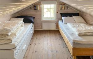 Duas camas num pequeno quarto com pisos em madeira em 5 Bedroom Gorgeous Home In Sjusjen em Sjusjøen