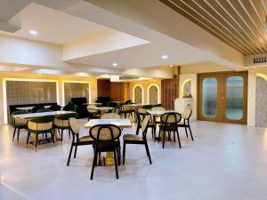 een eetkamer met tafels en stoelen en een bank bij Miloft Sathorn Hotel - SHA Plus Certified in Bangkok
