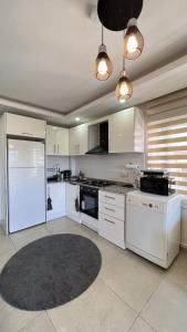 cocina grande con electrodomésticos blancos y alfombra en Anemon Residence, en Alanya