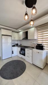 a large kitchen with white appliances and a rug at Anemon Residence in Alanya