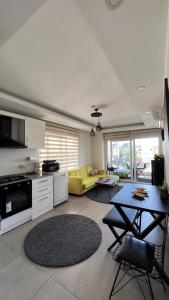 a kitchen and living room with a table and a yellow couch at Anemon Residence in Alanya