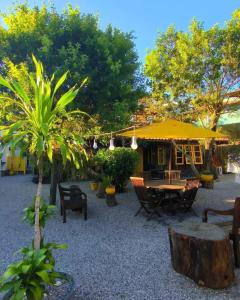 a patio with a table and a yellow umbrella at Toca Geribá in Búzios