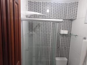a bathroom with a glass shower with a toilet at Brisa Brasil Residence in Fortaleza
