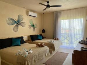1 dormitorio con 2 camas y ventilador de techo en sunsteps dragonfly room en Holbox Island