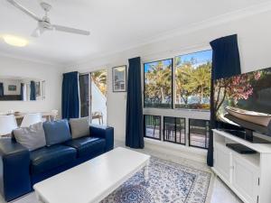 uma sala de estar com um sofá azul e uma grande janela em Arcadia Beach Unit 1 em Arcadia