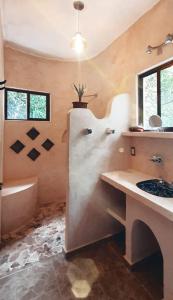 a bathroom with a mural of a face on the wall at Finca Oz in Homún