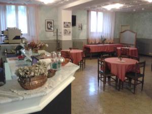 a dining room with tables and chairs with red table cloth at Hotel Italia Abbadia in Abbadia San Salvatore