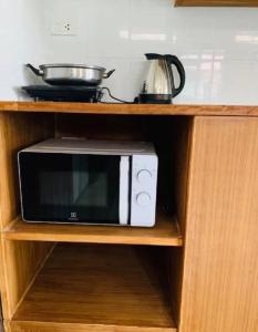 un four micro-ondes installé sur une étagère dans une cuisine dans l'établissement Phangan Chalet Bungalow & House, à Chaloklum