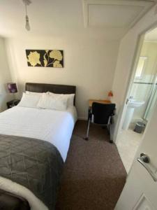 Un dormitorio con una cama y un escritorio con una silla. en Amama's Cabin, en Great Yarmouth