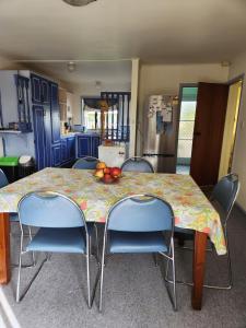 una cocina con una mesa con sillas y fruta. en Harakeke Homestay, en Hastings