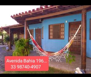 a house with a hammock in front of it at pousada residencial santos in Nova Viçosa