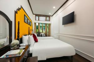 Schlafzimmer mit einem weißen Bett und einem TV in der Unterkunft Silk Castle Hotel & Spa in Hanoi