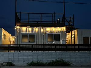 久米島町にあるOne World Activityの夜間灯が灯る建物