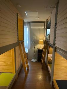 a room with two bunk beds and a fan at まちやど　Motomachi in Daigo