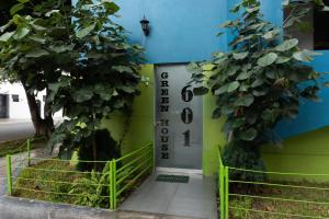 duas árvores ao lado de um edifício com uma porta em Green House em Lima