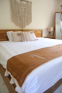 a large bed with a brown blanket on it at Kala Surf Camp in Uluwatu