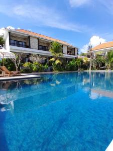 a large blue swimming pool in front of a building at Kala Surf Camp in Uluwatu