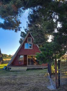 un granero rojo con una ventana en el costado en Cabaña Los Pinos, en Chonchi