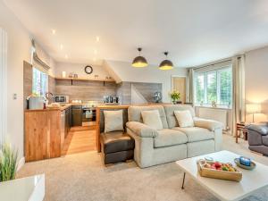a living room with a couch and a kitchen at Dower House Lodge in Lindridge