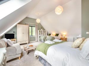 a attic bedroom with two beds and a couch at Dower House Lodge in Lindridge