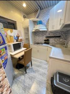 a kitchen with a sink and a desk with a microwave at Al Muftaha Apartment in Abha