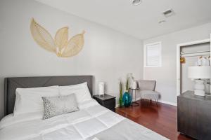 a bedroom with a white bed with a butterfly on the wall at Perfect Location! Stylish Condo Steps Away from Nationals Stadium and Navy Yard in DC's Southwest Gem in Washington, D.C.