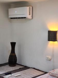 a room with a heater and a vase on a bed at Lomas Suites in La Africana