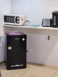 a microwave sitting on a counter next to a refrigerator at Lomas Suites in La Africana
