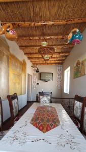 a dining room with a table with a rug on it at Guest House Art Postindoz in Khiva
