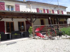 a red bike parked in front of a house at La Fontenelle Chambres d'Hôtes in Sainte-Sévère