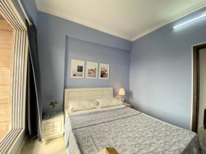 1 dormitorio con 1 cama grande y paredes azules en Angel Views 601, Chapel Road, Bandra West by Connekt Homes en Bombay