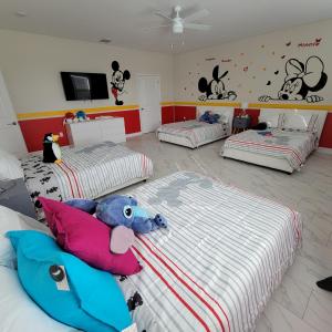 a bedroom with three beds with stuffed animals on them at Winterfield at Disney 9350 in Kissimmee