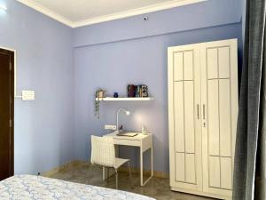 a bedroom with a desk with a lamp and a chair at Angel Views 601, Chapel Road, Bandra West by Connekt Homes in Mumbai