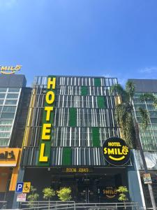 ein hohes Gebäude mit einem Schild an der Vorderseite in der Unterkunft Smile Hotel Klang Bukit Tinggi in Kampong Telok Gadong Besar