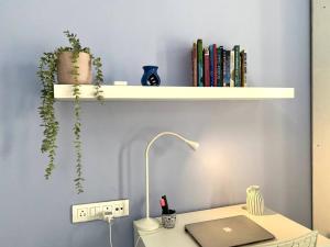 a desk with a laptop and a shelf with books at Angel Views 601, Chapel Road, Bandra West by Connekt Homes in Mumbai