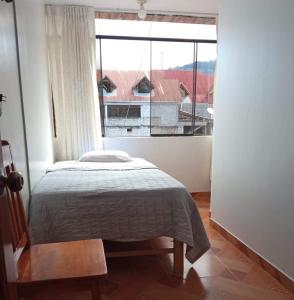 ein Schlafzimmer mit einem Bett und einem großen Fenster in der Unterkunft HOSPEDAJE GIMAJA in Villa Rica