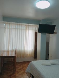 Schlafzimmer mit einem Bett, einem Tisch und einem Fenster in der Unterkunft HOSPEDAJE GIMAJA in Villa Rica
