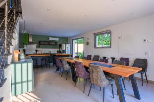 a kitchen and dining room with a wooden table and chairs at LES DRYADES MILLY in Milly-la-Forêt