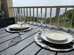 阿瓜迪亞的住宿－Sunset Vista Paradise，阳台上的桌子上摆放着盘子和酒杯