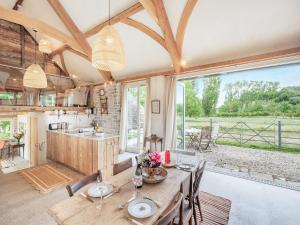 comedor con mesa y sillas y ventana grande en The Coach House, en Creech Saint Michael