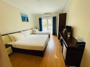 a hotel room with two beds and a television at Rising Dragon Hotel in Hanoi