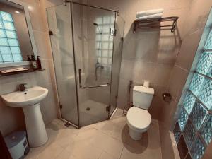 a bathroom with a shower and a toilet and a sink at Rising Dragon Hotel in Hanoi