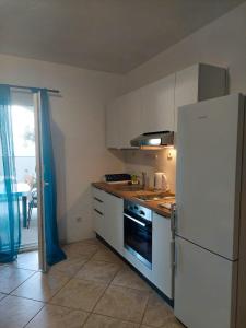 a kitchen with a white refrigerator and a stove at Olive Garden Apartments in Poljica